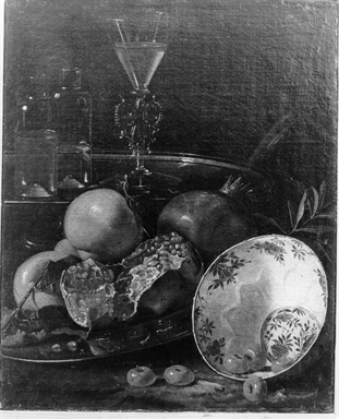 natura morta di frutta con ciotola decorata, due bottiglie e un bicchiere