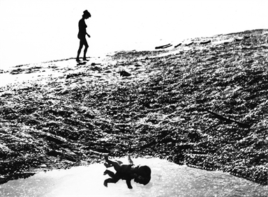 donna e bambola sulla spiaggia