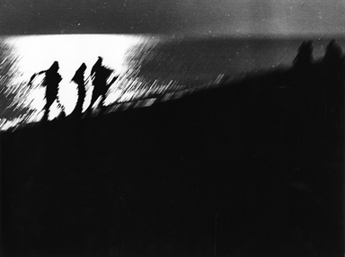 tre ombre di uomini sulla spiaggia di notte