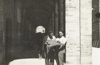 Ritratti maschili intenti nella lettura di un quotidiano sotto il portico nella Piazza Umberto I, attuale Piazza della Repubblica di Montefiore dell'Aso