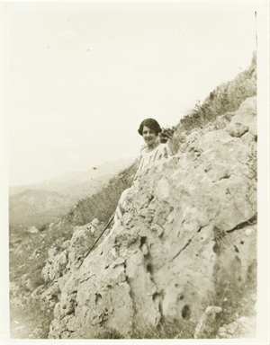 Figura femminile dietro una roccia