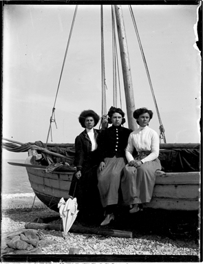 Ritratto di tre donne in riva al mare appoggiate ad una barca
