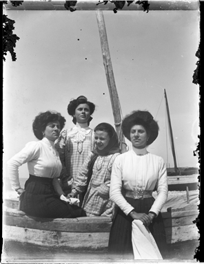 Ritratto di quattro donne in riva al mare appoggiate ad una barca