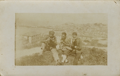 Un militare e due giovani ritratti mentre mangiano il cocomero