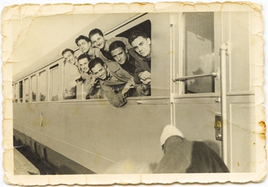 Giuseppe Del Zozzo, affacciato dal finestrino di un treno, con alcuni colleghi
