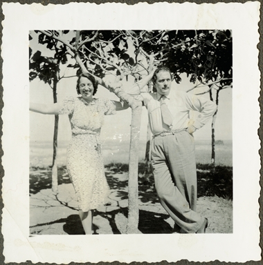 Duilio Baronti ritratto insieme ad una donna mentre abbracciano i rami di un albero